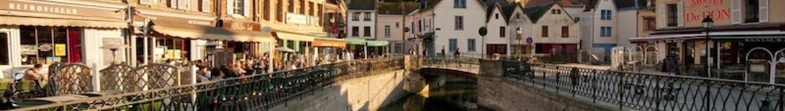 Amiens Glisy : Canal pittoresque avec café et église.