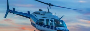Hélicoptère Bell 206 en vol avec couché de soleil